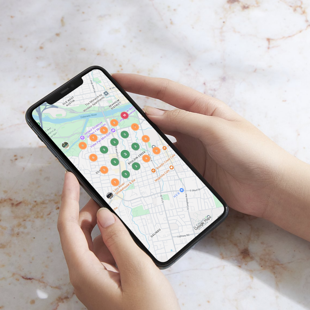 Person holding a phone showing a Google Maps search result with local business ranking markers